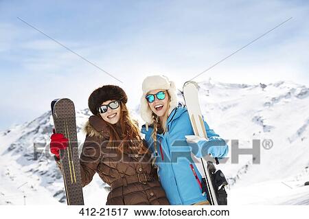 Friends holding skis on mountain top together View Large Photo Image Stock Photo - Friends holding skis on mountain top together. Fotosearch