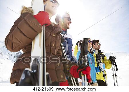 Friends standing with skis on mountain top View Large Photo Image Stock Photo - Friends standing with skis on mountain top. Fotosearch