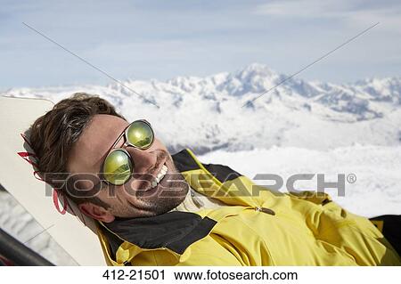 Man laying on a chair in the snow View Large Photo Image Stock Image - Man laying on a chair in the snow. Fotosearch