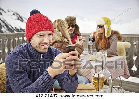 Man using cell phone on snowy balcony View Large Photo Image Stock Photo - Man using cell phone on snowy balcony . Fotosearch