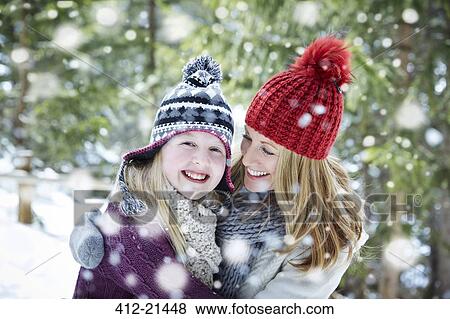 Stock Photo - Mother and daughter hugging in the snow. Fotosearch