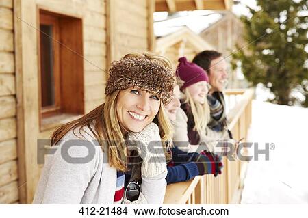 Mother standing on snowy balcony with family View Large Photo Image Picture - Mother standing on snowy balcony with family. Fotosearch