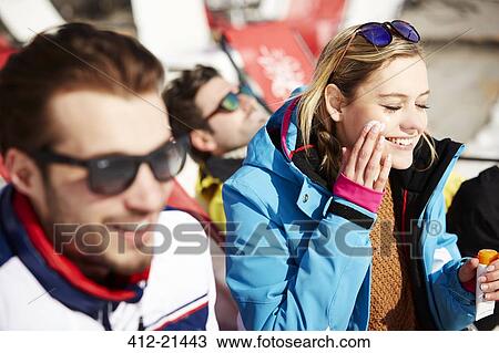 Woman applying sun screen while relaxing in the snow View Large Photo Image Stock Image - Woman applying sun screen while relaxing in the snow. Fotosearch