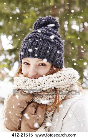 Stock Photography - Woman wearing scarf and hat in the snow . Fotosearch