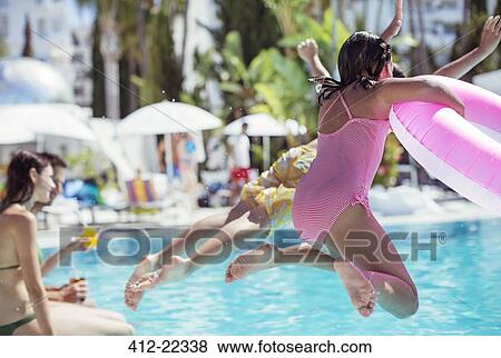 Stock Photo - Children jumping into resort swimming pool. Fotosearch