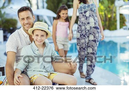 Family enjoying themselves by swimming pool View Large Photo Image Stock Photograph - Family enjoying themselves by swimming pool. Fotosearch