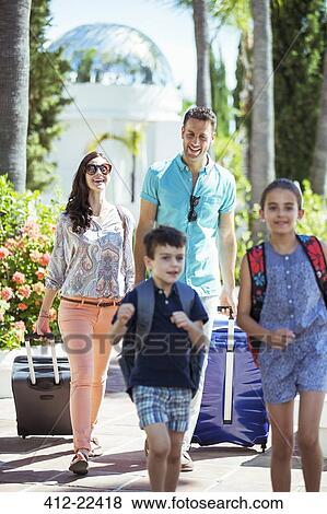 Family with luggage walking towards tourist resort View Large Photo Image Stock Photo - Family with luggage walking towards tourist resort. Fotosearch