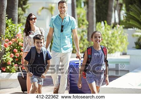 Family with suitcases walking towards tourist resort View Large Photo Image Stock Image - Family with suitcases walking towards tourist resort. Fotosearch