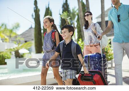 Family with suitcases walking towards tourist resort View Large Photo Image Stock Photo - Family with suitcases walking towards tourist resort. Fotosearch