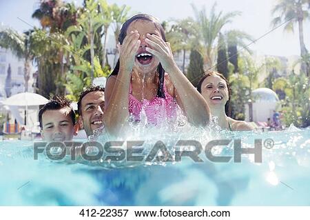 Stock Photo - Family with two children enjoying themselves in swimming pool. Fotosearch