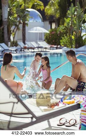 Family with two children splashing water in resort swimming pool View Large Photo Image Stock Image - Family with two children splashing water in resort swimming pool. Fotosearch
