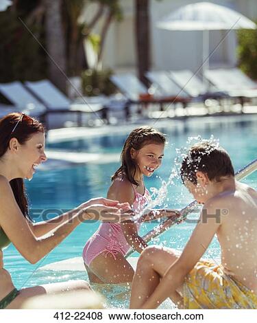 Family with two children splashing water in resort swimming pool View Large Photo Image Stock Photo - Family with two children splashing water in resort swimming pool. Fotosearch