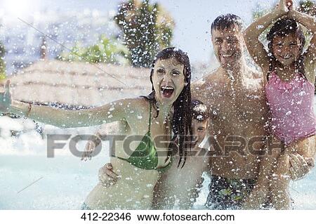 Family with two children splashing water and laughing in swimming pool View Large Photo Image Stock Photograph - Family with two children splashing water and laughing in swimming pool. Fotosearch