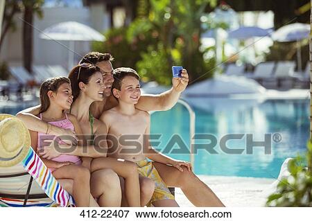 Family with two children taking selfie by swimming pool View Large Photo Image Stock Photo - Family with two children taking selfie by swimming pool. Fotosearch