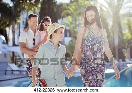 Stock Photograph - Family with two children walking by swimming pool. Fotosearch