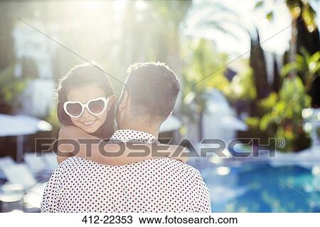 Father carrying daughter wearing heart shaped sunglasses by swimming pool View Large Photo Image Stock Image - Father carrying daughter wearing heart shaped sunglasses by swimming pool. Fotosearch