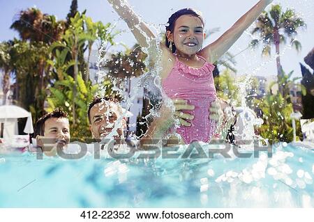 Stock Image - Father playing with son and daughter in swimming pool. Fotosearch