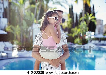 Man carrying his daughter by swimming pool View Large Photo Image Stock Photography - Man carrying his daughter by swimming pool. Fotosearch