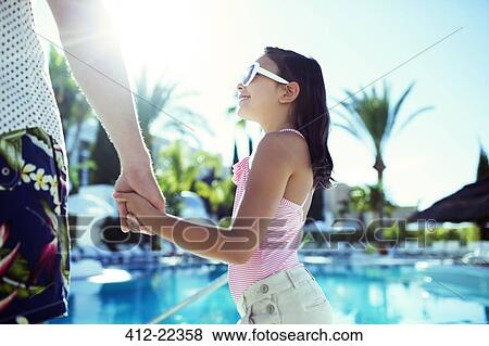 Man holding hands with his daughter by swimming pool View Large Photo Image Stock Photo - Man holding hands with his daughter by swimming pool. Fotosearch