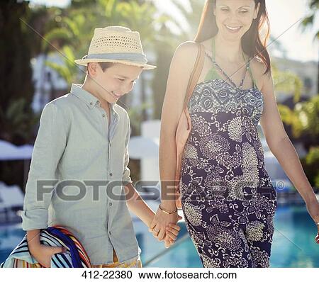 Mother and son holding hands by swimming pool View Large Photo Image Stock Image - Mother and son holding hands by swimming pool. Fotosearch