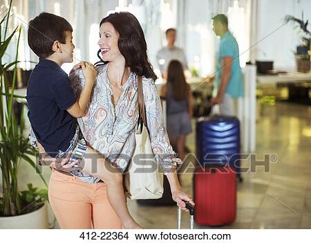 Picture - Mother carrying son in hotel lobby. Fotosearch