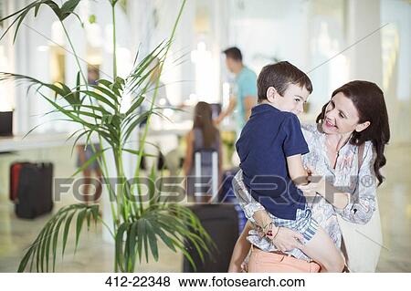 Stock Photo - Mother carrying son in hotel lobby. Fotosearch