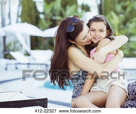 Mother embracing her daughter on poolside View Large Photo Image Stock Photo - Mother embracing her daughter on poolside. Fotosearch