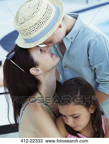 Stock Image - Mother hugging son and daughter. Fotosearch