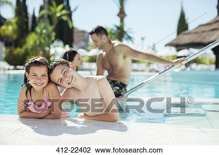 Stock Image - Portrait of smiling boy and girl in swimming pool. Fotosearch