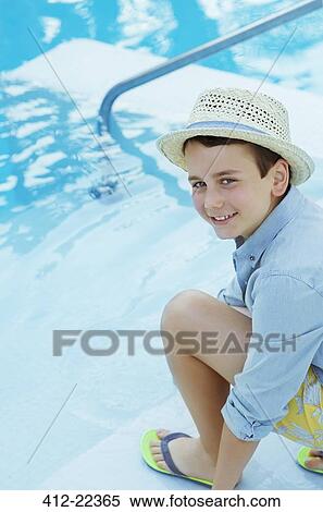 Portrait of smiling boy wearing straw hat crouching by swimming pool View Large Photo Image Stock Photography - Portrait of smiling boy wearing straw hat crouching by swimming pool. Fotosearch