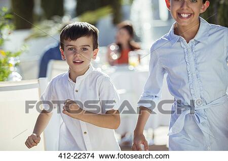 Picture - Smiling boy and girl running towards camera outdoors. Fotosearch