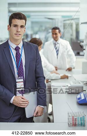 Businessman holding laptop in laboratory View Large Photo Image Stock Image - Businessman holding laptop in laboratory. Fotosearch