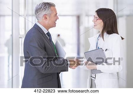 Scientist and businessman shaking hands in hallway View Large Photo Image Stock Image - Scientist and businessman shaking hands in hallway. Fotosearch