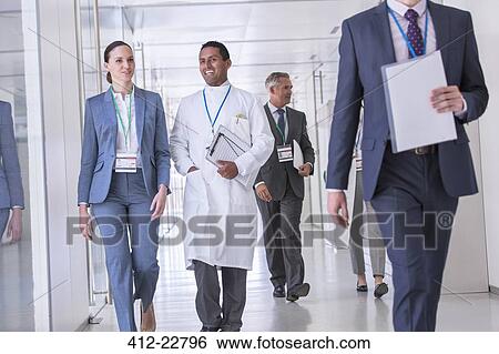 Scientist and businesswoman talking in hallway View Large Photo Image Stock Photograph - Scientist and businesswoman talking in hallway. Fotosearch