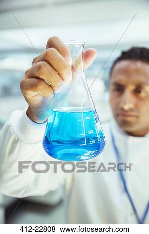 Stock Photo - Scientist examining sample in beaker in laboratory. Fotosearch