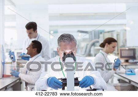 Scientist examining sample under microscope in laboratory View Large Photo Image Stock Image - Scientist examining sample under microscope in laboratory. Fotosearch