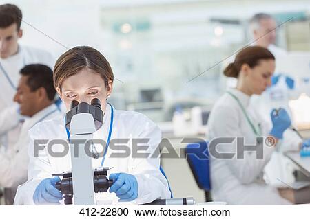 Scientist examining sample under microscope in laboratory View Large Photo Image Stock Image - Scientist examining sample under microscope in laboratory. Fotosearch