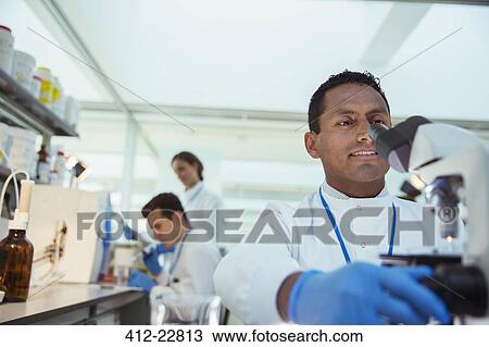 Scientist examining sample under microscope in laboratory View Large Photo Image Stock Image - Scientist examining sample under microscope in laboratory. Fotosearch