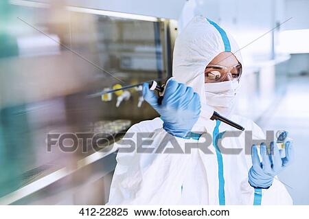 Scientist in clean suit pipetting sample into Petri dish in laboratory View Large Photo Image Stock Photography - Scientist in clean suit pipetting sample into Petri dish in laboratory. Fotosearch