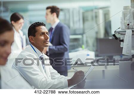 Scientist taking notes on experiment in laboratory View Large Photo Image Stock Photo - Scientist taking notes on experiment in laboratory. Fotosearch