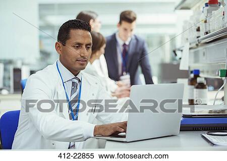 Stock Photography - Scientist using laptop in laboratory. Fotosearch