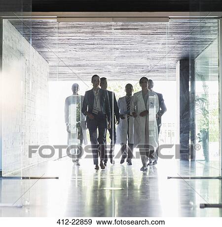 Scientists and business people approaching glass doors View Large Photo Image Stock Photo - Scientists and business people approaching glass doors. Fotosearch