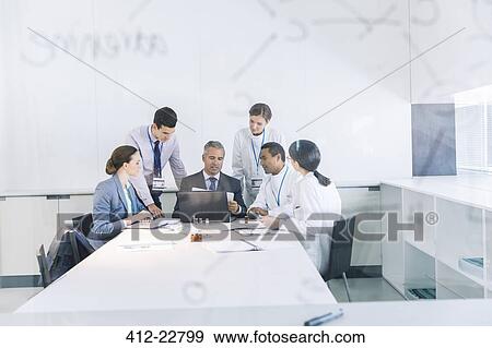 Stock Photo - Scientists and business people talking in conference room. Fotosearch