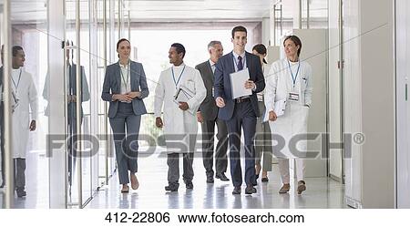 Stock Photograph - Scientists and business people walking in hallway. Fotosearch