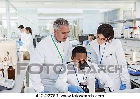 Stock Photo - Scientists using microscope in laboratory. Fotosearch