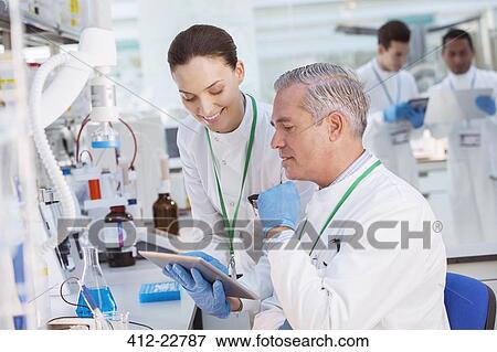 Stock Photo - Scientists using tablet computer in laboratory. Fotosearch