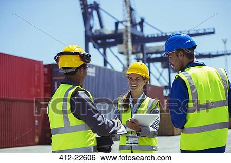 Stock Photograph - Business people and worker talking near cargo containers. Fotosearch