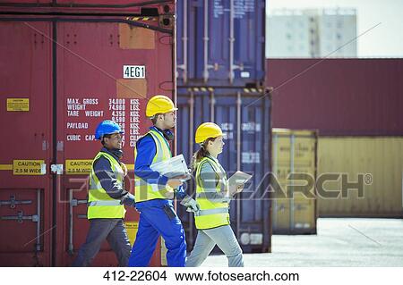 Business people and worker walking near cargo containers View Large Photo Image Picture - Business people and worker walking near cargo containers. Fotosearch