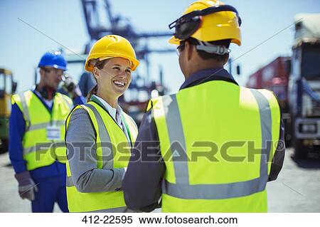 Business people wearing protective workwear talking View Large Photo Image Stock Photography - Business people wearing protective workwear talking. Fotosearch