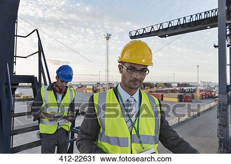 Businessman smiling near cargo crane View Large Photo Image Stock Image - Businessman smiling near cargo crane. Fotosearch